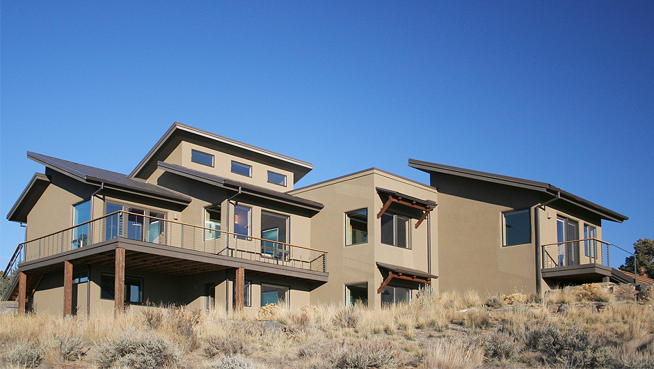 Criss Cross Southwest Elevation Southwest elevation with large south facing windows, protective awnings, large Trex decks, and criss crossed roofs